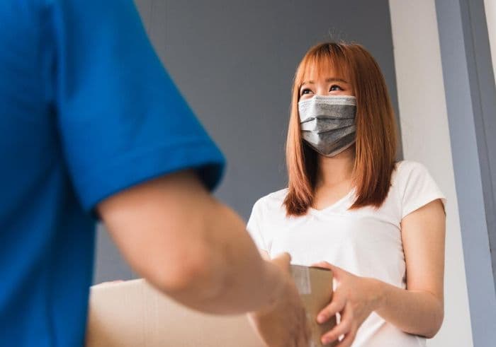 A woman receiving a package from a medical courier service